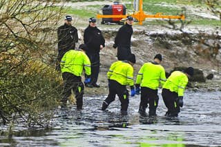 Policajti prehľadávajú jazero deň po tragédii.