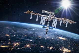 International space station in 2022 in outer space with Earth at night. ISS floating on orbit of nightly Earth planet.