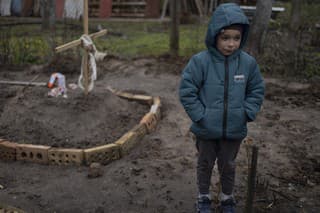 Na snímke je 6-ročný chlapec Vlad, ktorý stojí vedľa hrobu svojej matky. Počas vojny na Ukrajine zomrela od hladu.