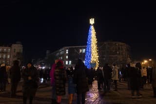 Ľudia počas rozsvietenia vianočného stromčeka vo farbách ukrajinskej národnej zástavy v Kyjeve 19. decembra 2022.