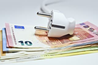 The electric plug placed on a stack of euro banknotes.
