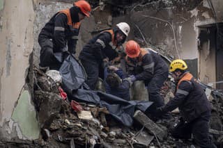 Záchranári nesú telo muža, ktorý zahynul po ruskom raketovom útoku na obytný dom 16. januára 2023 v ukrajinskom meste Dnipro.