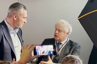 Na videosnímke bývalý britský premiér Boris Johnson (vpravo), ktorý si preberá čestnú medailu 