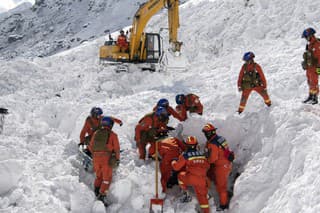 Záchranári hľadajú v snehu nezvestné osoby po lavíne.