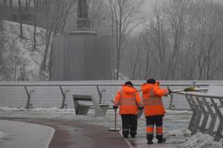 Mestskí zamestnanci odhrabávajú sneh v parku v Kyjeve v sobotu 14. januára 2023.