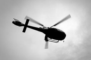 Black and white silhouette of helicopter from low angle view