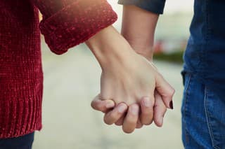 Cropped shot of a couple holding hands outdoors
