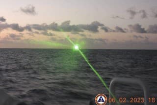 Na snímke z 6. februára 2023 zelený vojenský laserový lúč z lode čínskej pobrežnej stráže v spornom Juhočínskom mori.