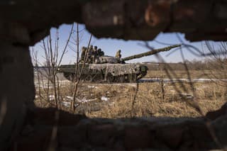 Ukrajinskí vojaci 3. samostatnej tankovej brigády jazdia na tanku počas cvičenia v Charkovskej oblasti na Ukrajine.
