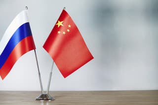 Chinese and Russian flag standing on the table with defocused background