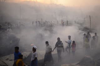 Rohinskí utečenci sa snažia zachrániť svoj majetok po masívnom požiari, ktorý zachvátil utečenecký tábor.
