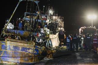 Polícia kontroluje rybársku loď s približne 500 migrantmi v juhotalianskom prístave Crotone v sobotu 11. marca 2023. 