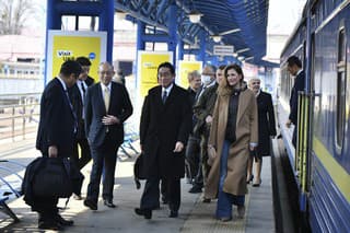 Japonský premiér Fumio Kišida (uprostred) a prvá námestníčka ukrajinského ministerstva zahraničných vecí Emine Džaparovová (vpravo) kráčajú po nástupišti na železničnej stanici v Kyjeve.