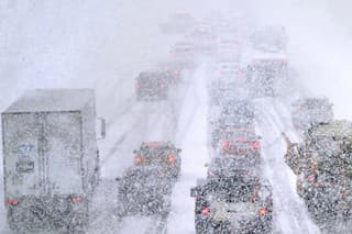 Snežné pluhy sú v zápche na ceste v americkom meste Londonderry počas hustého sneženia.