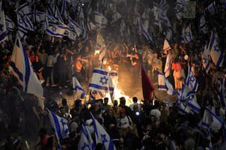 Izraelčania, ktorí nesúhlasia s plánom premiéra Benjamina Netanjahua na revíziu súdnictva, zakladajú ohne a blokujú cestu po odvolaní izraelského ministra obrany Joava Galanta.