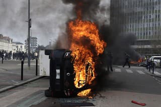 Prevrátené auto horí počas demonštrácie proti reforme dôchodkového systému v Nantes.