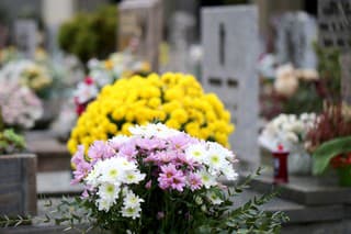 yellow and white flowers on the grave of a cemetery to remember a dead relative