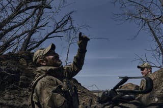Ukrajinský vojak ukazuje na ruský dron zo zákopu na frontovej línii v Bachmute 10. apríla 2023.