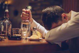 One man, sitting at the bar counter alone, he has drinking problems, sleeping on bar counter.