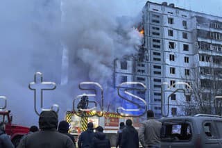 Hasiči sa snažia uhasiť požiar po zásahu budovy ruskou raketou.