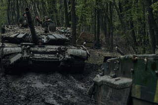 Ukrajinskí vojaci mávajú z tanku na frontovej línii v Bachmute.