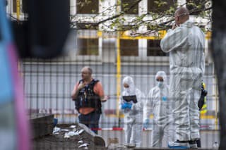 Forenzní experti stoja pred základnou školou po útoku nožom v berlínskej štvrti Neukölln.