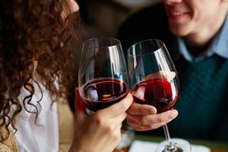 Amorous couple toasting with red wine in restaurant