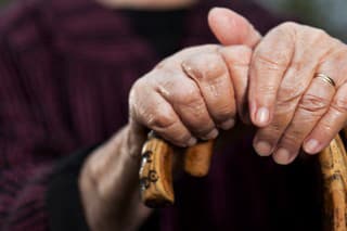 Close-up of senior woman's hands holding her walking sticks. Selective focus on hands and sticks.