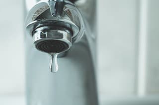 water drop dripping from the tap and water shortage
