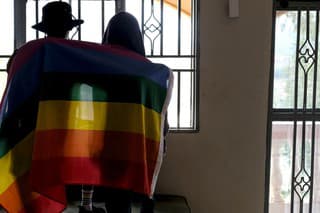 Na archívnej snímke z 25. marca 2023 homosexuálny pár pózuje s dúhovou vlajkou v Ugande. 