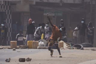 Demonštrant hádže kameň na policajtov počas potýčok v Dakare v Senegale vo štvrtok 1. júna 2023.