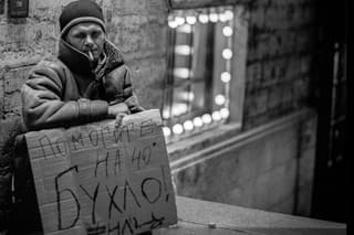 Archívna fotka Rusa sediaceho pred reštauráciou v Petrohrade, ktorý pýta peniaze na alkohol.