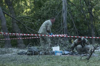 Policajti zbierajú dôkazy po raketovom útoku ruskej armády v Kyjeve.