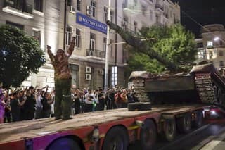  Žoldnieri z Vagnerovej skupiny nakladajú svoj tank na nákladné auto na ulici v Rostove na Done.