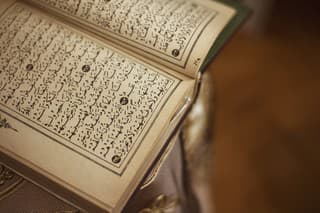 Directly above view of Quran with old pages standing on the table.