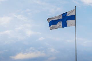 Finnish Flag - National Flag of Finland on a blue sky - Helsinki, Finland