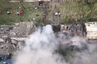  Na videosnímke hasiči zasahujú na mieste zničenej budovy po ruskom raketovom útoku v ukrajinskom Mykolajive