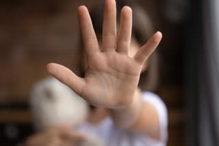 Crop close up of little girl child stretch hand show no gesture protest against domestic violence. Small teen child stand against discrimination or school abuse. Childhood problem, voice concept.