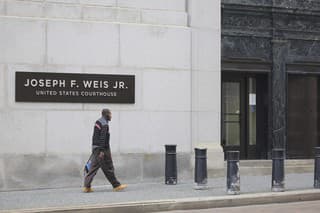 Muž prechádza okolo budovy súdu Spojených štátov amerických Josepha F. Weisa Jr. počas rokovania federálnej poroty o rozsudku nad Robertom Bowersom v Pittsburghu v stredu 2. augusta 2023.