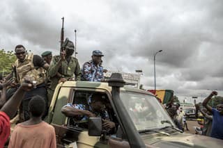 Ľudia v Nigeri oslavujú počas toho, ako bezpečnostné sily jazdia ulicami hlavného mesta Bamako.
