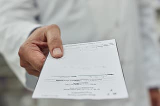 Cropped shot of a pharmacist holding a prescription form