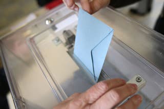 France. 05/06/2012. This colorful image depicts a man placing an election envelope in a plastic ballot box at a polling station.