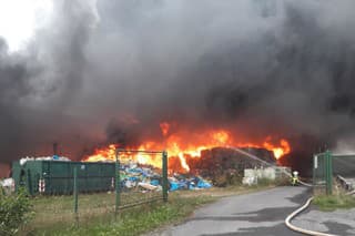Hasiči zasahujú pri požiari v triediarni odpadov v Dolných Hbitoch na Příbramsku 25. augusta 2023.