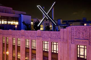 Pracovníci inštalujú logo spoločnosti X (donedávna známej pod názvom Twitter), umiestnené na streche jej sídla v kalifornskom San Franciscu 28. júla 2023.