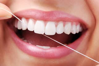 Beautiful smiling model with dental floss- XXXL Image