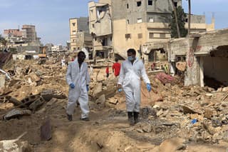 Záchranári prehľadávajú pomocou ťažkých mechanizmov trosky zničených budov a pátrajú po preživších po ničivých záplavách v líbyjskom meste Darna 17. septembra 2023.