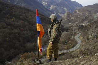 Na archívnej snímke zo stredy 25. novembra 2020 etnický arménsky vojak stojí na stráži vedľa vlajky Náhorného Karabachu na vrchole kopca.