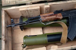 Kalashnikov AK47 gun and "Bazooka" RPG grenade launchers in army green crate