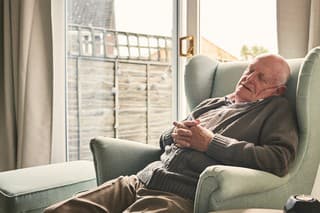 Indoor shot of retired senior adult sleeping on chair at home