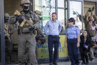 Príslušníci špeciálnej zásahovej jednotky kosovskej polície eskortujú z budovy súdu jedného zo zatknutých srbských ozbrojencov po nedeľňajšej prestrelke s kosovskou políciou v hlavnom meste Priština v utorok 26. septembra 2023. 